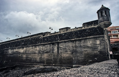 A fortified base with watchtowers and barricades under a stormy sky.