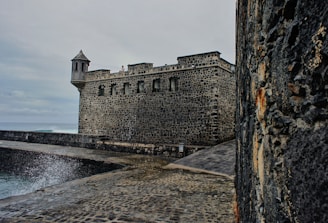 A stormy weather effect on a fortress battle map, with dark clouds and wet stone paths.