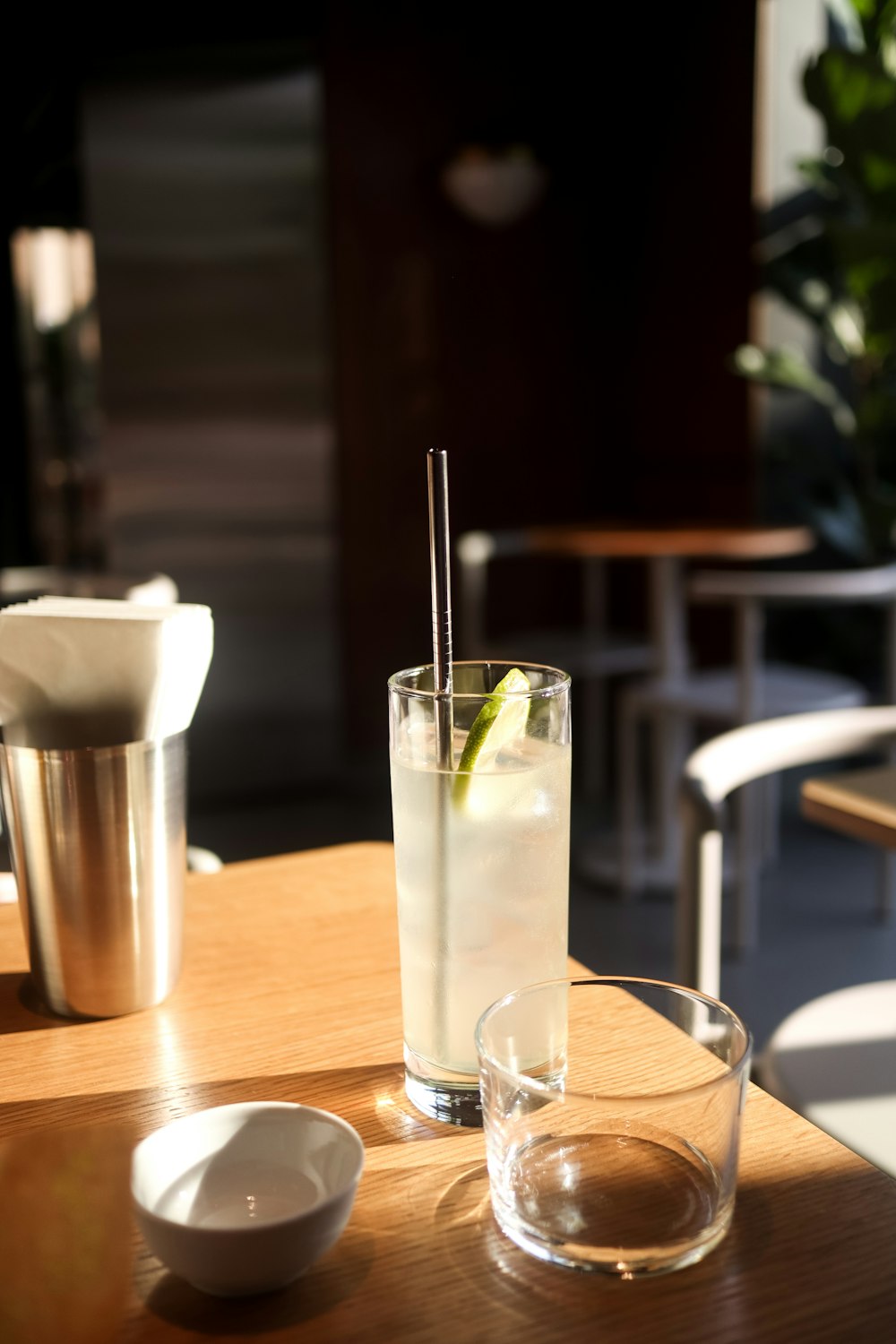 a glass of water and a spoon on a table