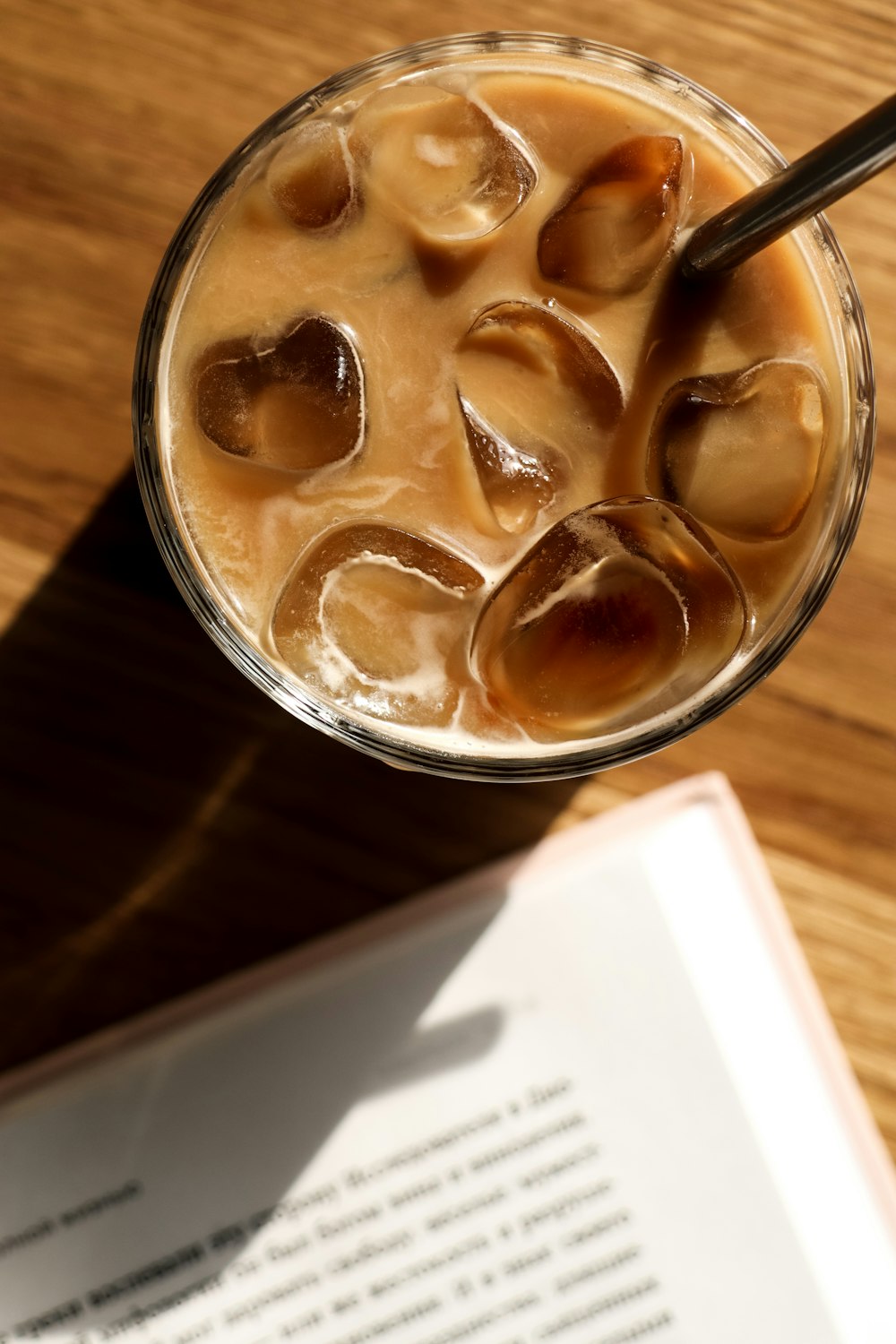 a glass of ice tea sitting on top of a wooden table