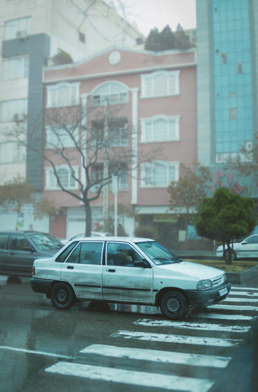 a white car parked in front of a tall building