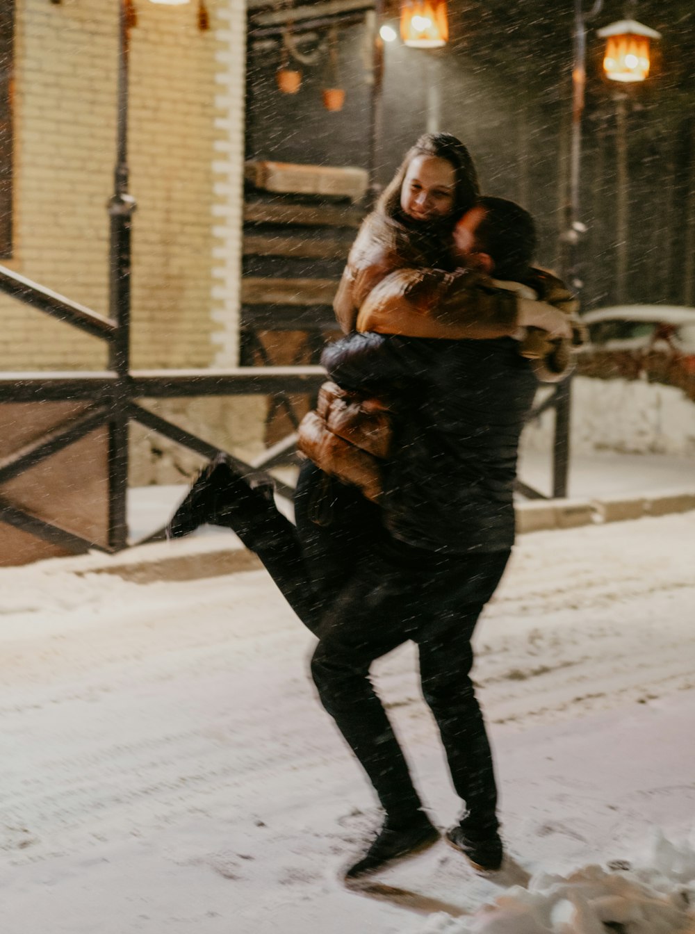 a man carrying a woman on his back in the snow