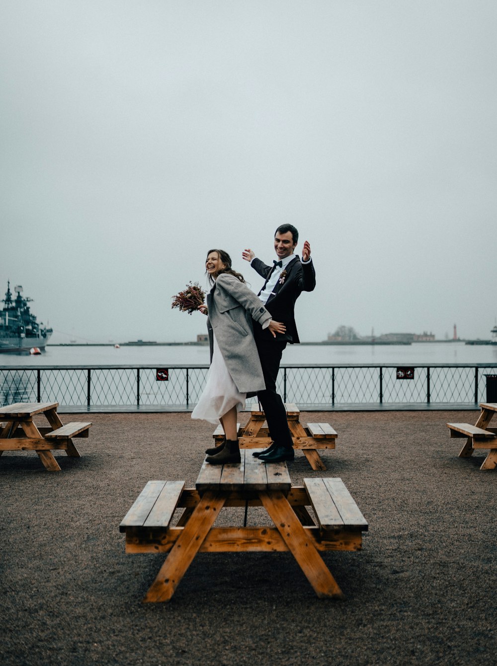 a man and a woman standing on a picnic table