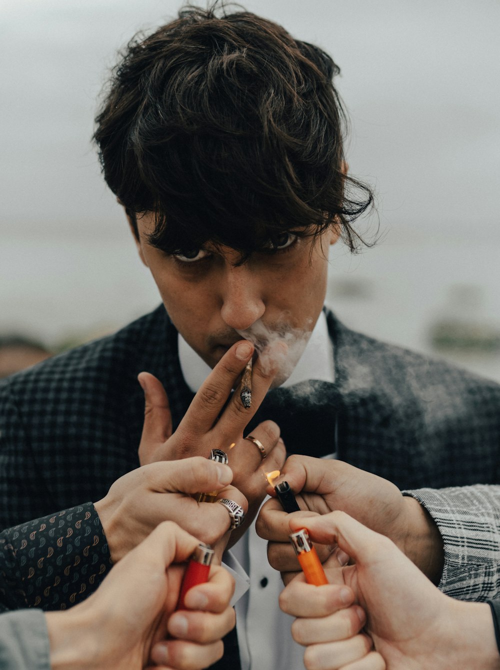 a man in a suit smoking a cigarette