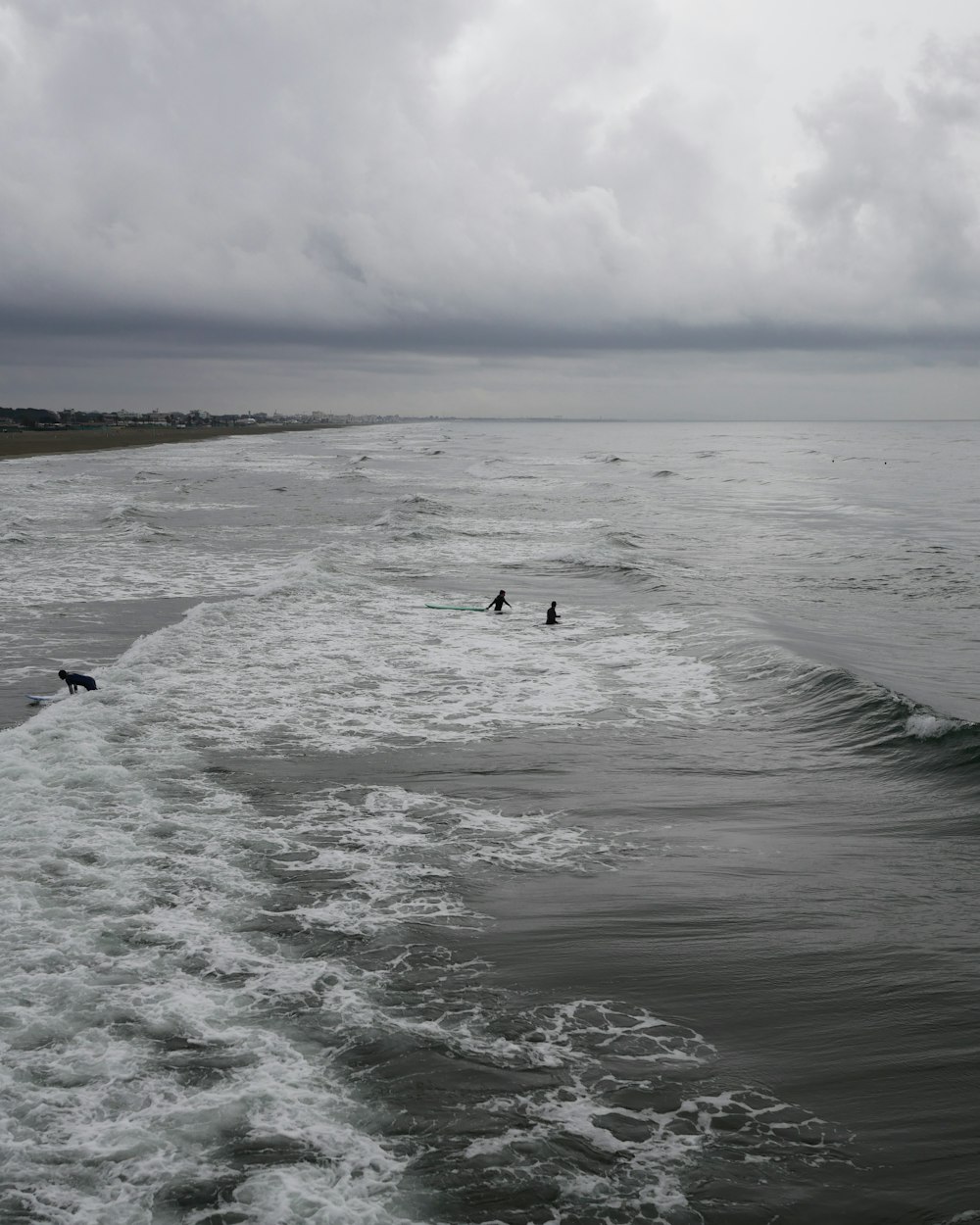 a couple of people riding surfboards on top of a wave