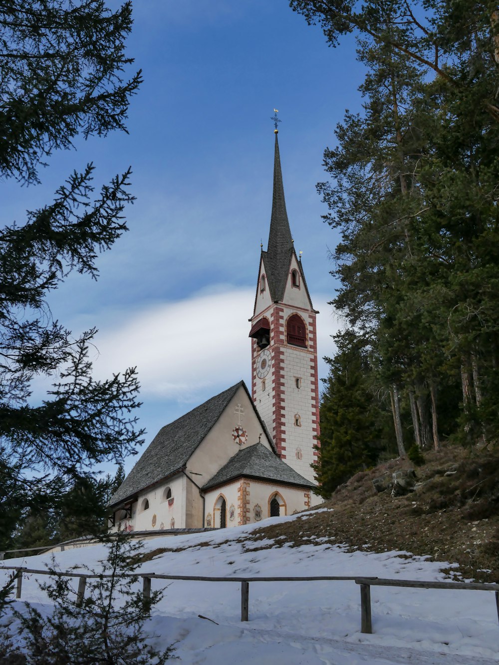 a church with a steeple surrounded by trees