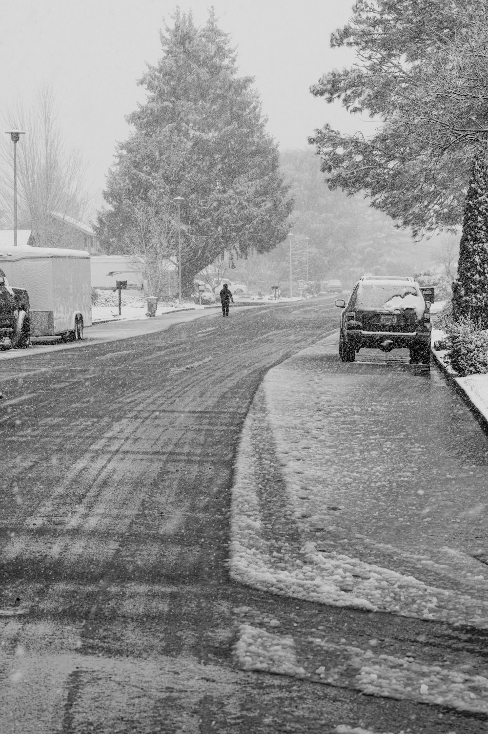 a black and white photo of a snowy street