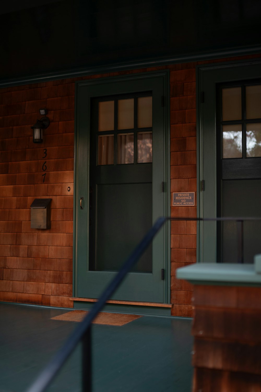 a green door and a brown brick building