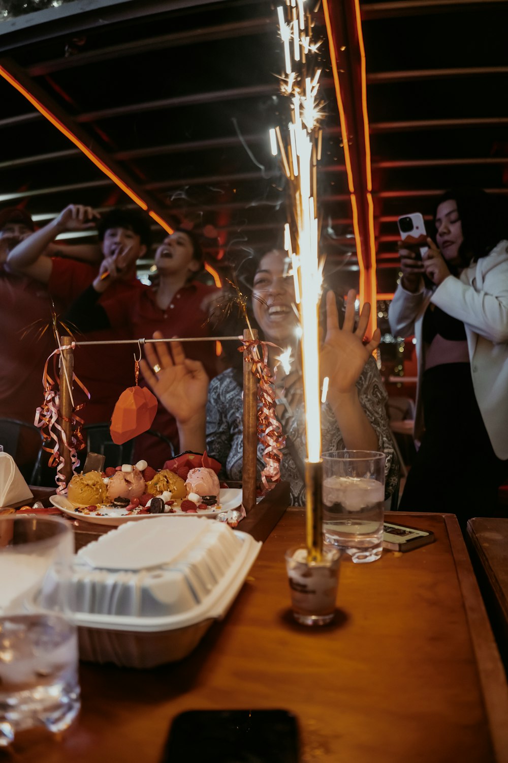 a group of people sitting around a table with a cake