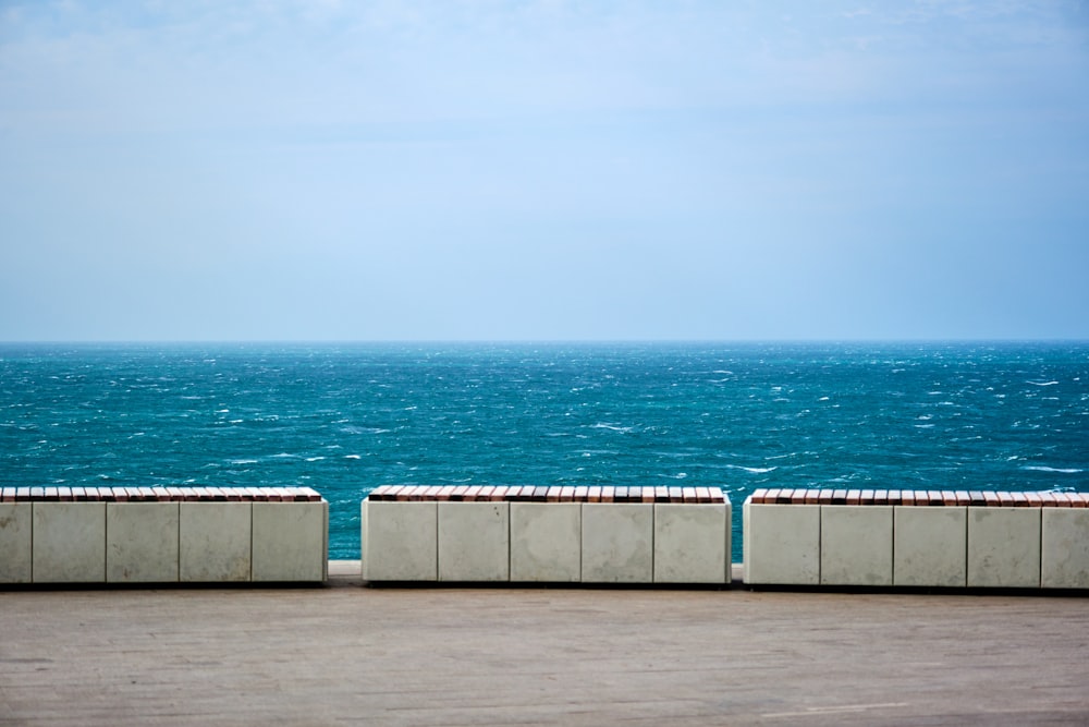 a couple of cement benches sitting next to a large body of water