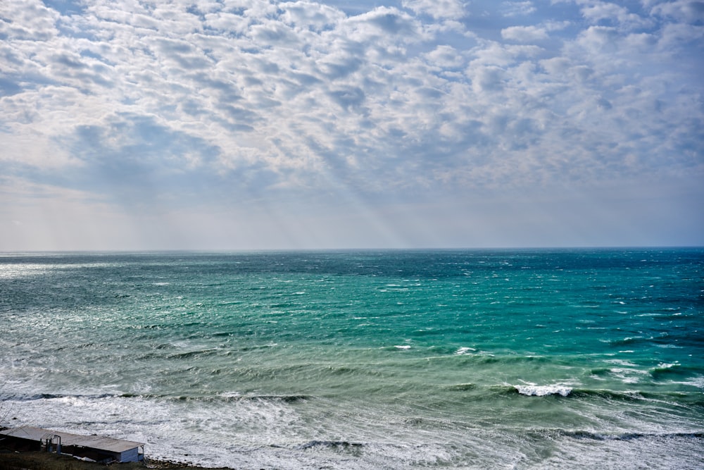 a view of a body of water with clouds in the sky