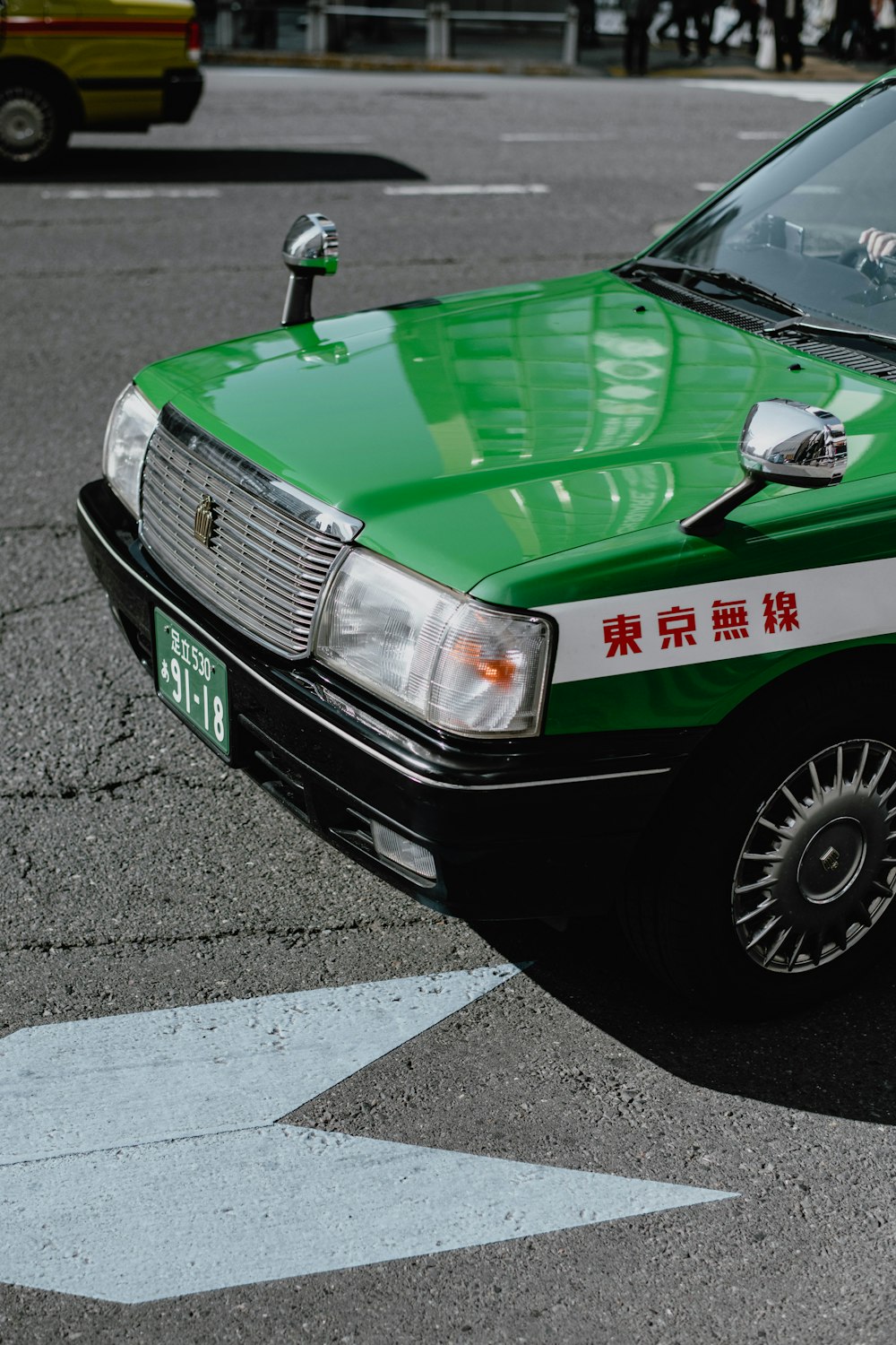 a green taxi cab parked in a parking lot