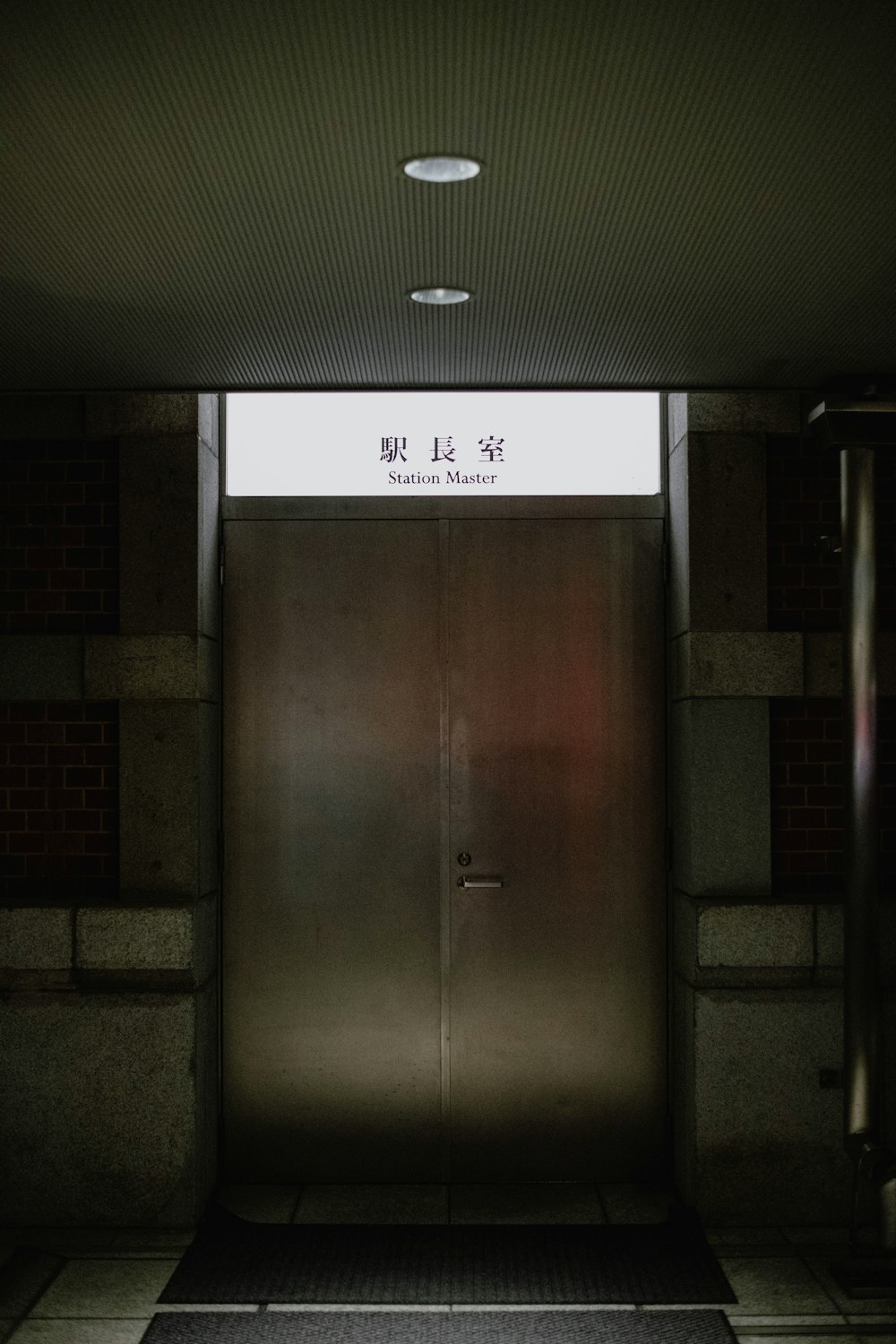 a very tall metal door in a very dimly lit room