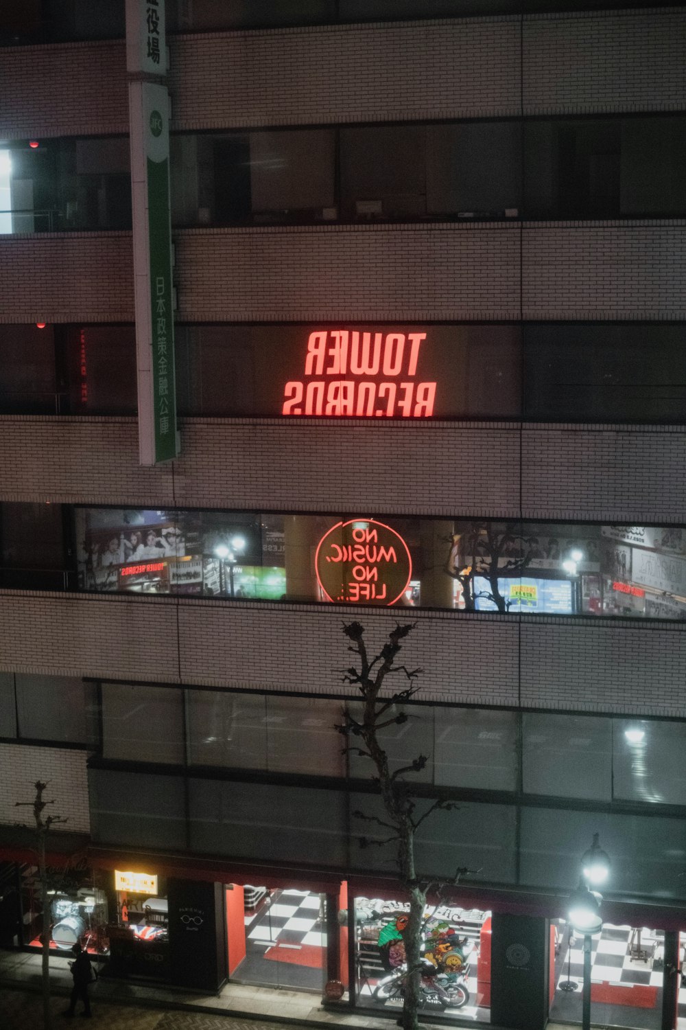 a tall building with a neon sign on the side of it