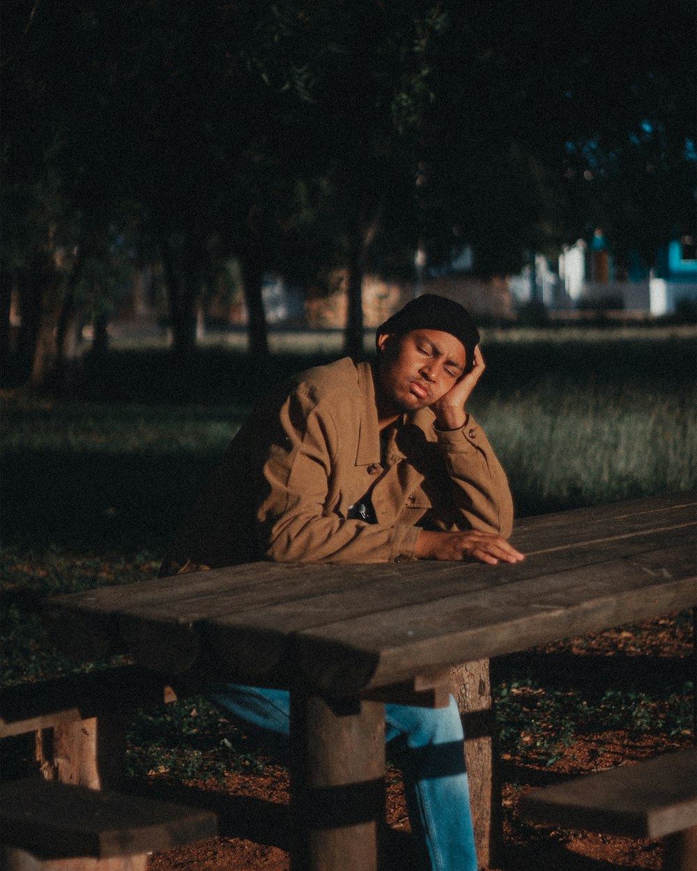 a man sitting at a picnic table in a park