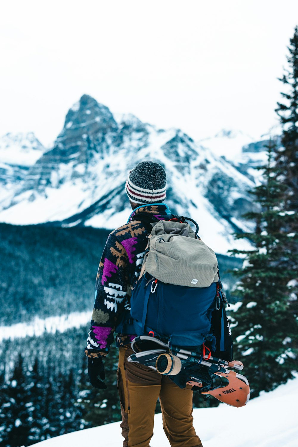 a person with a backpack and snowboard on a mountain