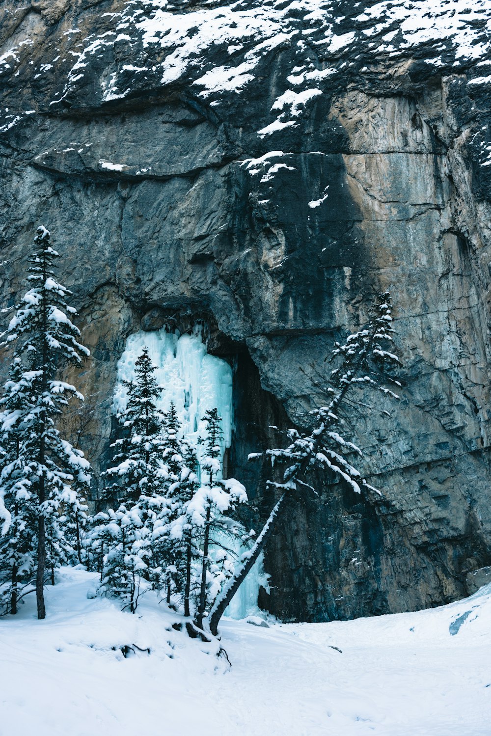 a snow covered mountain with a cave in the middle of it