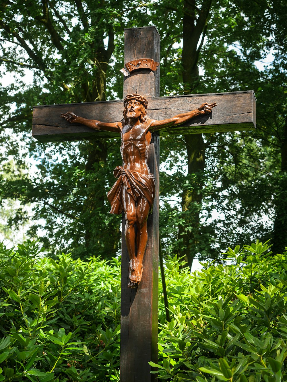 a wooden cross with a statue of jesus on it