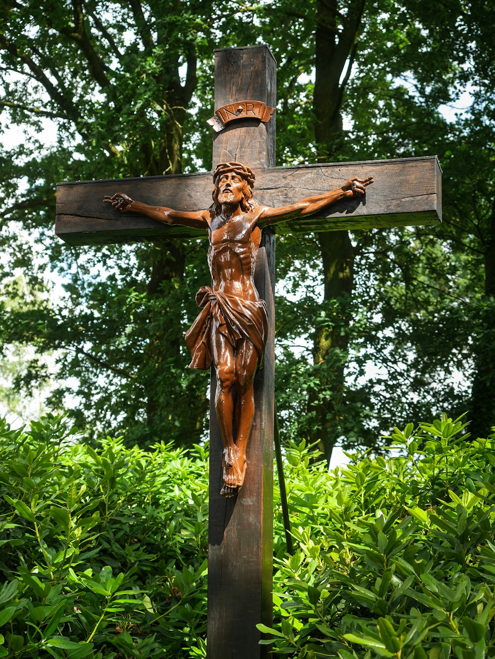 uma cruz de madeira com uma estátua de Jesus sobre ela