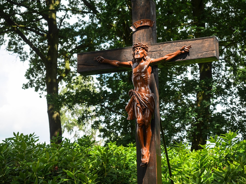 uma cruz de madeira com uma estátua de Jesus sobre ela