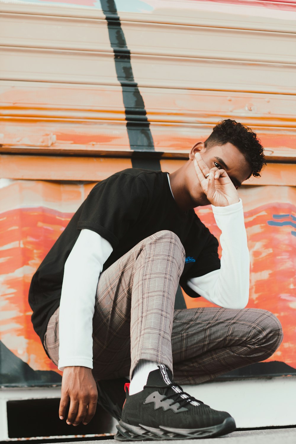 a man sitting on the ground while talking on a cell phone