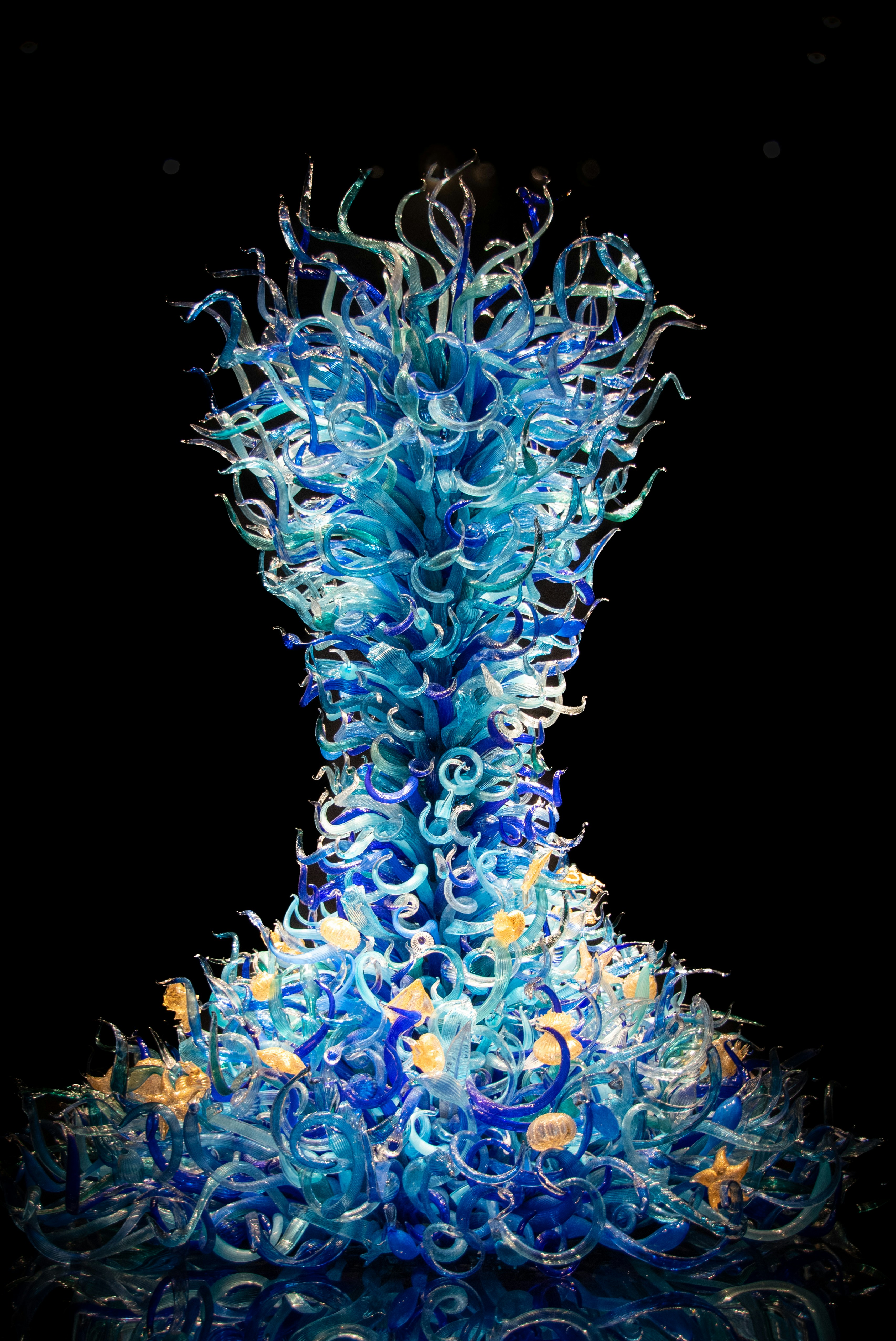 a blue glass sculpture sitting on top of a table