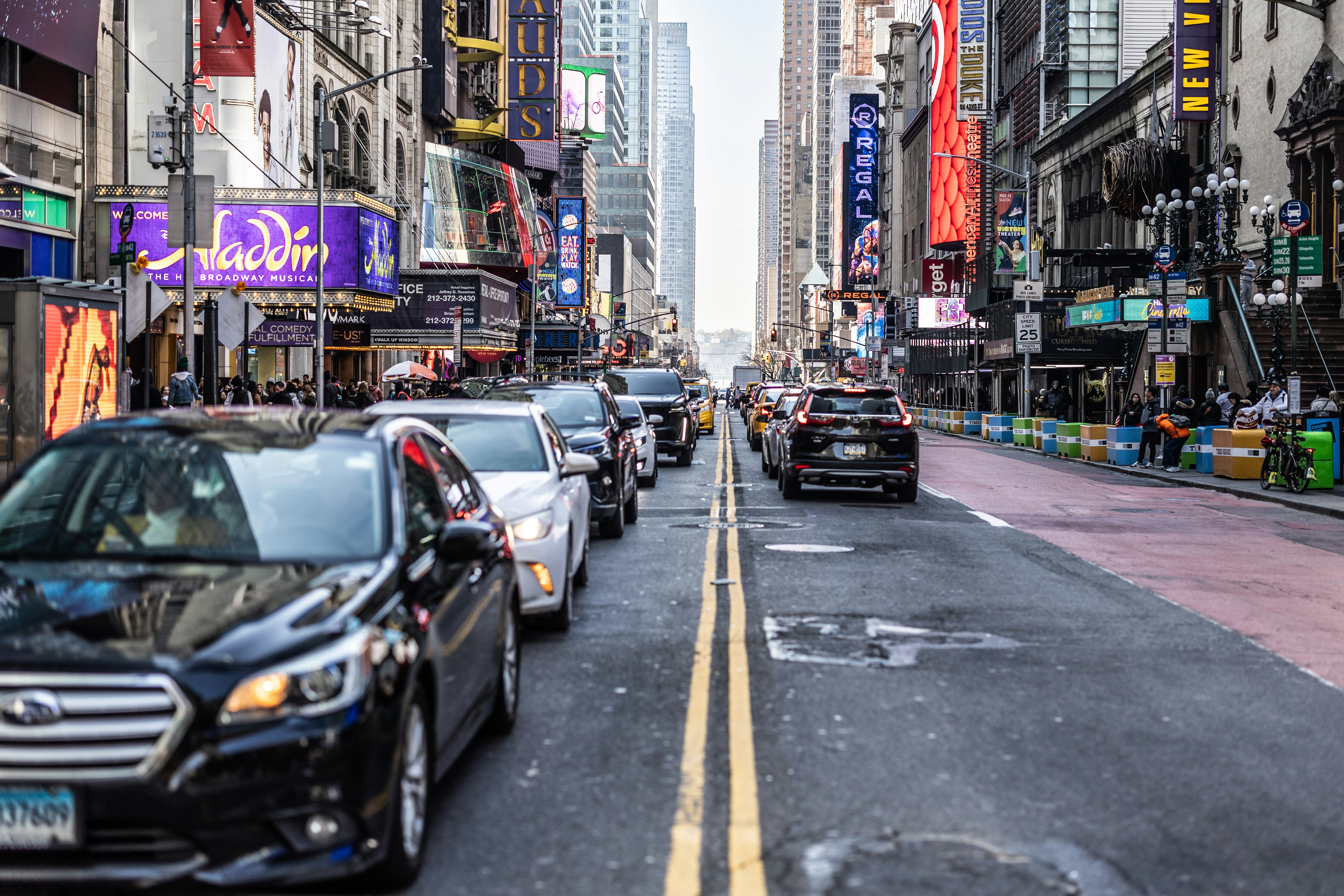a city street filled with lots of traffic next to tall buildings