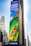 A large outdoor advertisement on a skyscraper depicts a family enjoying a water slide. The text on the advertisement reads 'Visit Orlando' and 'Anything is possible if you can imagine it.' The colors are vibrant, including a bright blue sky and a green water slide.