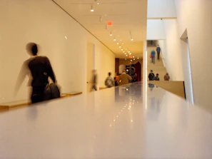 Blurred motion of people walking in a busy office hallway, illustrating pressure and change.