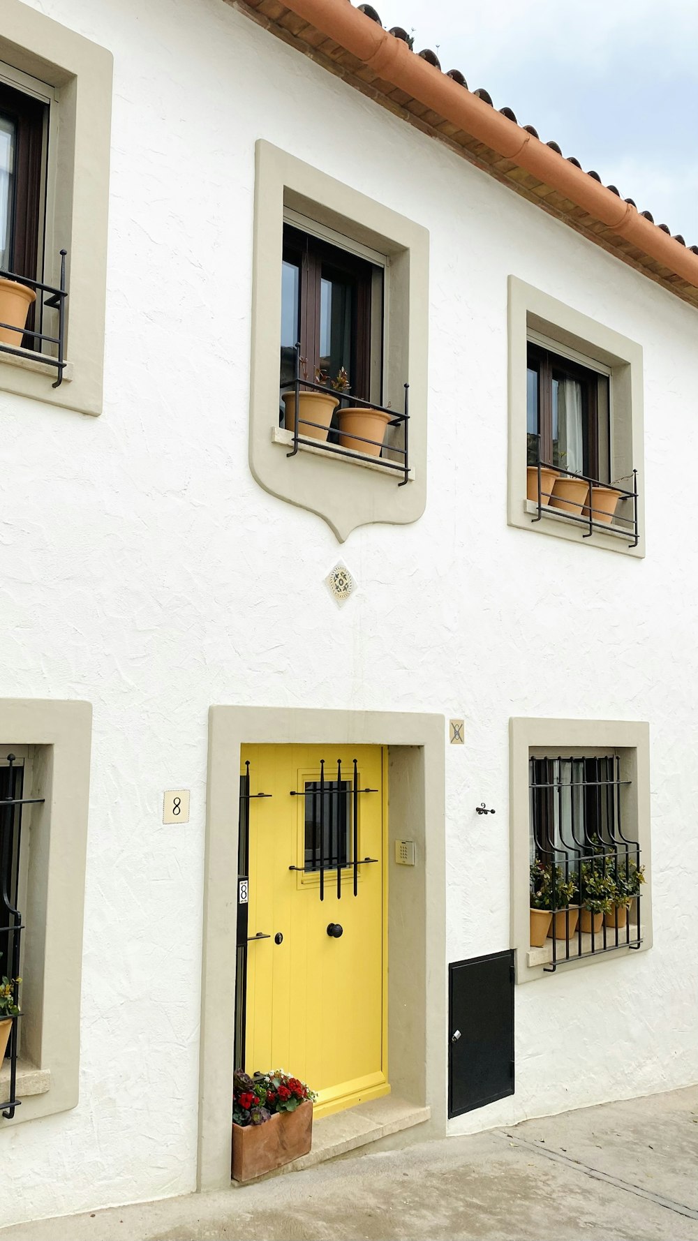 a white building with a yellow door and windows