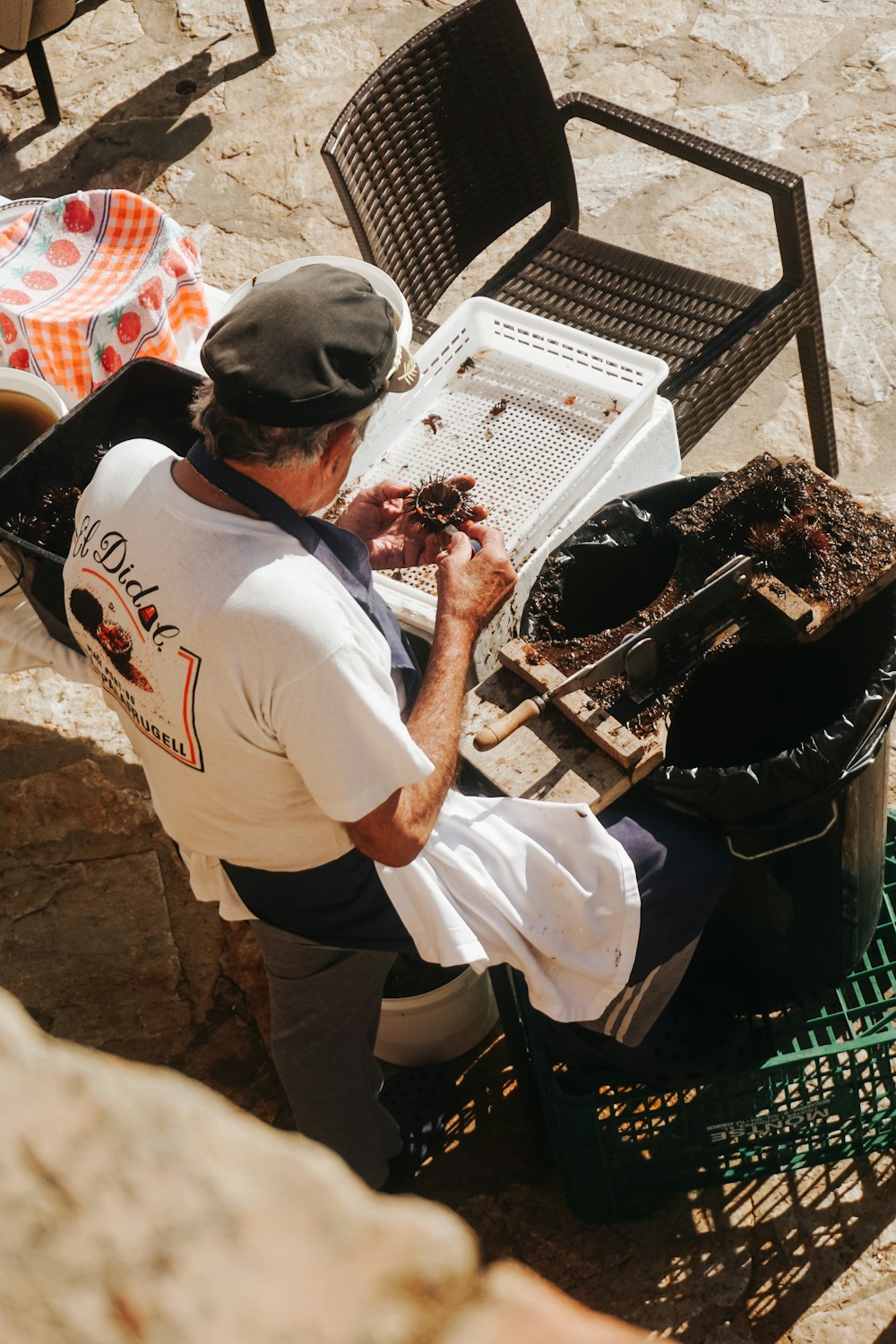 a man sitting at a table next to a grill