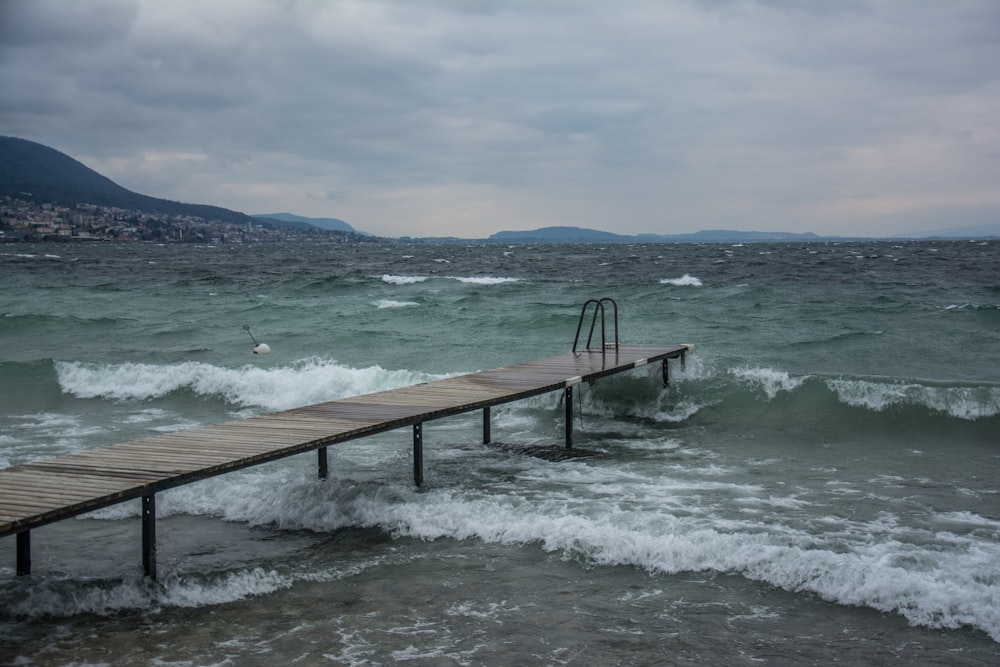 a wooden pier in the middle of the ocean