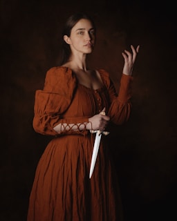 a woman in a brown dress holding a knife