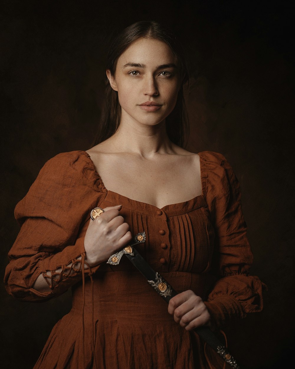 a woman in a brown dress holding a knife