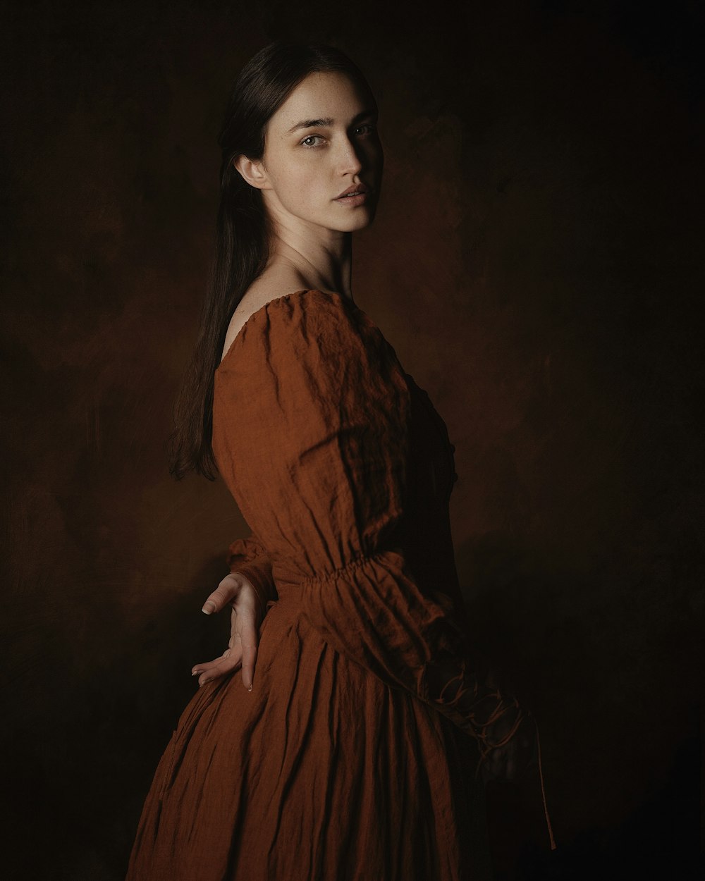 uma mulher em um vestido marrom posa para uma imagem