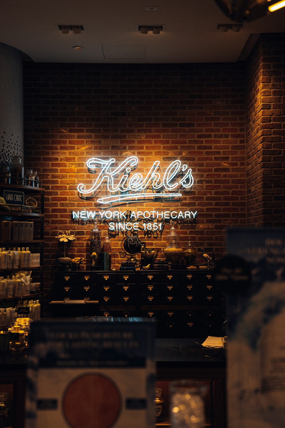 a brick wall with a neon sign above it