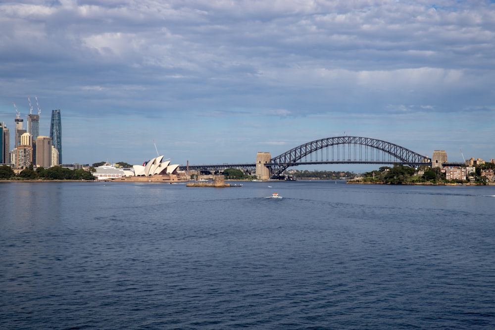 a large body of water with a bridge in the background