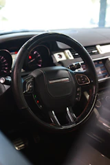 Sleek steering wheel with leather grip inside a modern car interior.