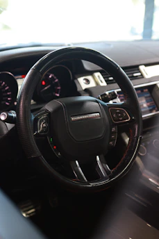 Sleek steering wheel with leather grip inside a modern car interior.
