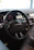 Close-up of a sleek black steering wheel installed in a car interior.