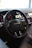 Close-up of a sleek black steering wheel installed in a car interior.
