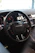 Close-up of a sleek black steering wheel installed in a car interior.