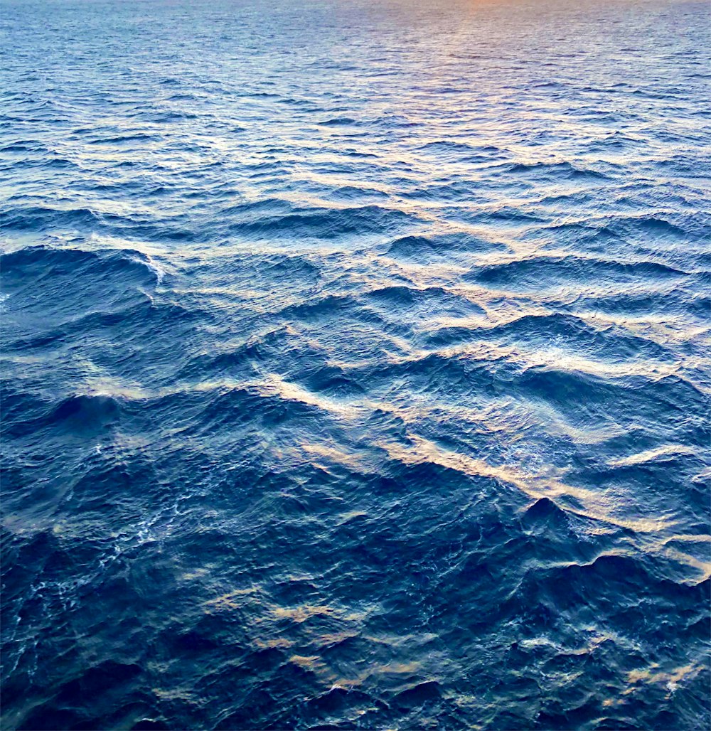 a large body of water with a boat in the distance