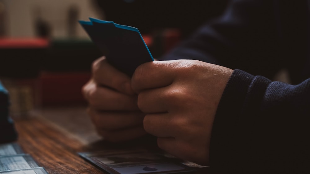 a person sitting at a table using a cell phone