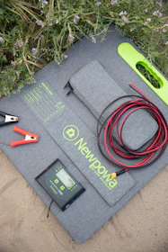 A sleek solar panel kit laid out with all components on a wooden table.