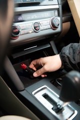 Electrician tracing wiring faults inside a vehicle dashboard.