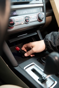 Technician connecting electrical diagnostic equipment inside a car dashboard at fitting centre