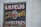 A vintage-style advertisement painted on a brick wall features large text that reads 'G.M. Fields Fresh and Smoked Meats' accompanied by an illustration of a cow's head. The sign also mentions 'Groceries' at the bottom.