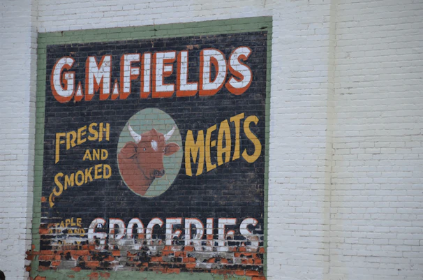 Golden logo of a veal head elegantly displayed on the side of the black mobile butcher van.