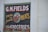 A vintage-style advertisement painted on a brick wall features large text that reads 'G.M. Fields Fresh and Smoked Meats' accompanied by an illustration of a cow's head. The sign also mentions 'Groceries' at the bottom.